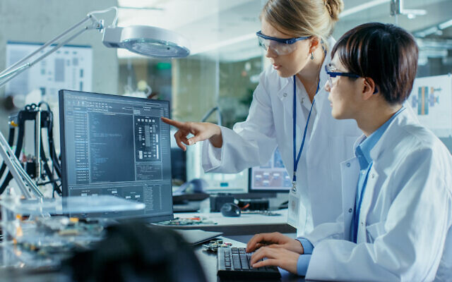 Illustrative: A scientist sits at his desk and consults an engineer about sophisticated coding and programming at a computer science research laboratory. (iStock by Getty Images)