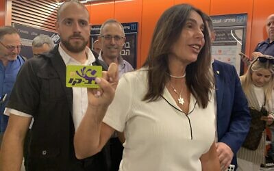 Transportation Minister Miri Regev holds up a Rav-Kav card given to her by a member of the press, before entering Allenby Station, August 16, 2023. (Charlie Summers/Times of Israel)