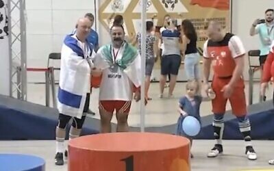 Mostafa Rajaei (R) shakes hands with  Israeli weightlifter Maksim Svirsky at a World Masters championship in Wieliczka, Poland on August 26, 2023 (Screencapture/X: used in accordance with Clause 27a of the Copyright Law)