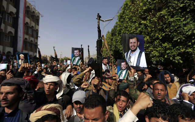 Supporters of Yemen's Houthi rebels raise portraits of their leader Abdul Malik Al-Houthi during a rally in the capital Sanaa on June 3, 2022. (Mohammed Huwais/AFP)