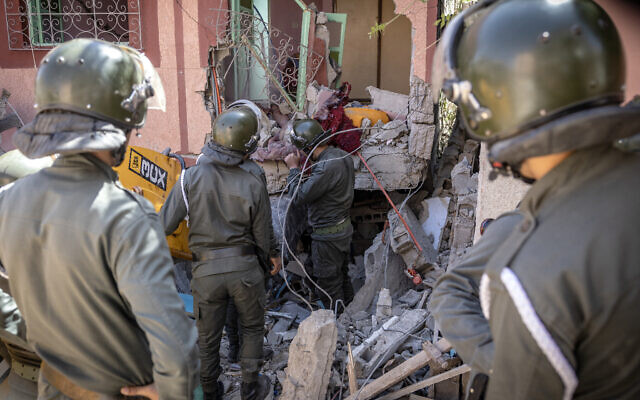 Rescuers use a small excavator to search for survivors under the rubble of a collapsed house in Moulay Brahim, Al Haouz province, Morocco, on September 9, 2023, after an earthquake. (Fadel Senna/AFP)