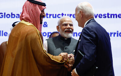 India's Prime Minister Narendra Modi (center), US President Joe Biden (roght) and Saudi Arabia's Crown Prince and Prime Minister Mohammed bin Salman hold hands before the start of a session at the G20 summit in New Delhi on September 9, 2023. (EVELYN HOCKSTEIN / POOL / AFP)