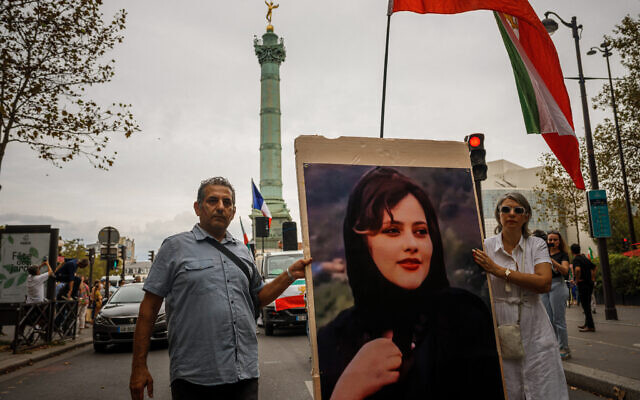 Demonstrators carry a portrait depicting late Mahsa Amini as they attend a protest against the Iranian regime in front of the Place de La Bastille in Paris on September 16, 2023, on the first anniversary of the death of Mahsa Amini in Iran. (Dimitar DILKOFF/AFP)