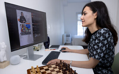French-Iranian chess player Mitra Hejazipour watches Iranian news at home in Paris, France, on September 15, 2023. (JOEL SAGET/AFP)