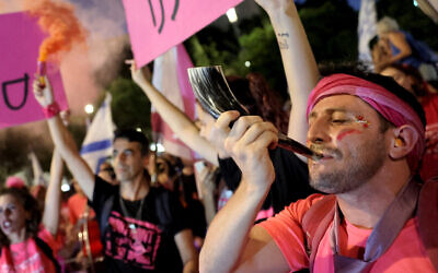 A demonstrator blows a Shofar, a traditional Jewish horn blown during the High Holidays, during a rally against the coalition's judicial overhaul, in Tel Aviv, September 23, 2023. (JACK GUEZ/AFP)