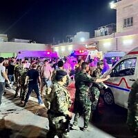 Soldiers and emergency responders gather around ambulances carrying wounded people after a fire broke out during a wedding at an event hall, outside the Hamdaniyah general hospital in Al-Hamdaniyah, Iraq on September 27, 2023. (Zaid AL-OBEIDI / AFP)