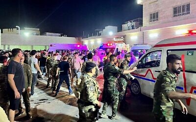 Soldiers and emergency responders gather around ambulances carrying wounded people after a fire broke out during a wedding at an event hall, outside the Hamdaniyah general hospital in Al-Hamdaniyah, Iraq on September 27, 2023. (Zaid AL-OBEIDI / AFP)