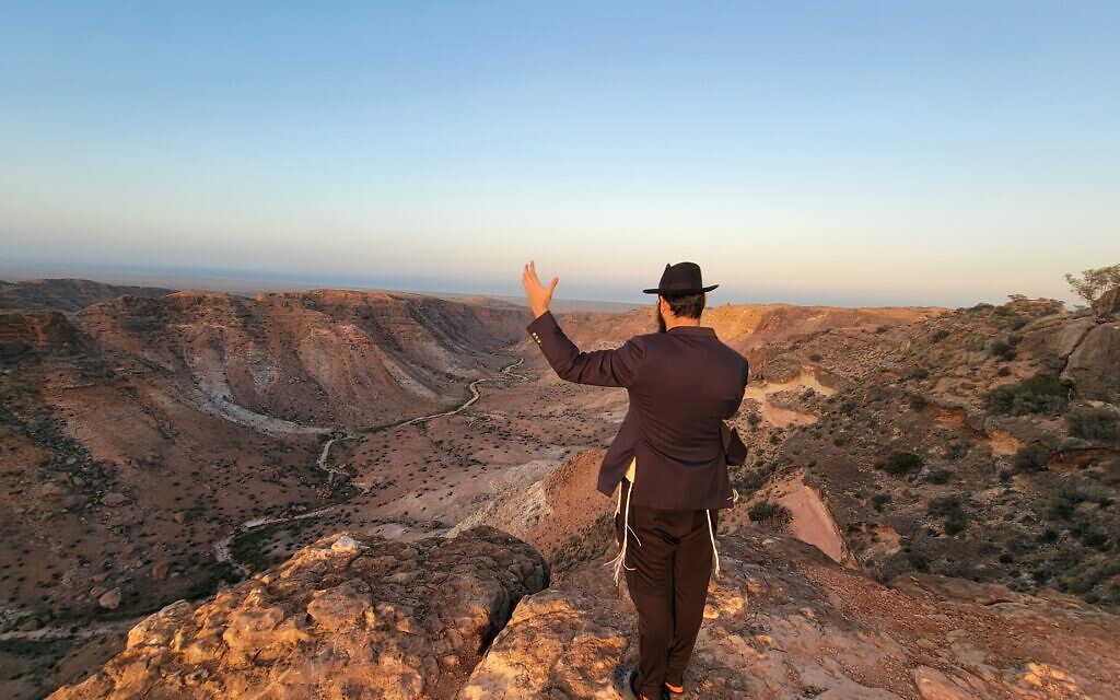 Rabbi Mendel Junik prays while overlooking the rugged outback of the Pilbara region in western Australia. (Courtesy of Rabbi Menachem Aron via JTA)
