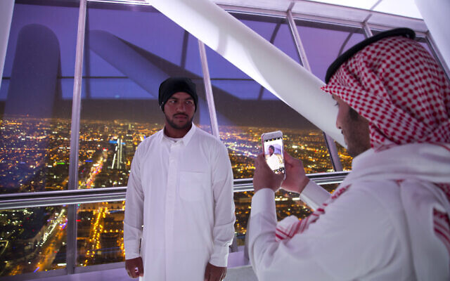 In this March 9, 2018 photo, visitors of Al Mamlaka tower, a 99-story skyscraper, take pictures with city view of Riyadh, Saudi Arabia. (AP Photo/Amr Nabil)