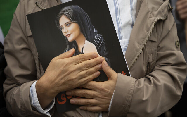 A portrait of Mahsa Amini is held during a rally calling for regime change in Iran following the death of Amini, a young woman who died after being arrested in Tehran by Iran's notorious 'morality police,' in Washington, on October 1, 2022. (AP Photo/Cliff Owen, File)