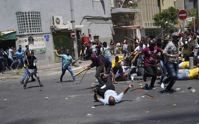 Anti-Eritrean government activists, left, clash with supporters of the Eritrean government, in Tel Aviv, Israel, Sept. 2, 2023 (AP Photo/Ohad Zwigenberg)