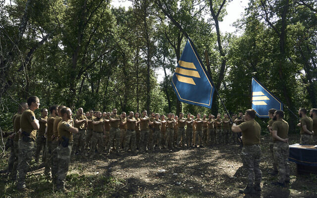 Soldiers of Ukraine's 3rd Separate Assault Brigade shout slogans as they stand in line, near Bakhmut, the site of fierce battles with the Russian forces in the Donetsk region, Ukraine, Sunday, Sept. 3, 2023. (AP/Libkos)
