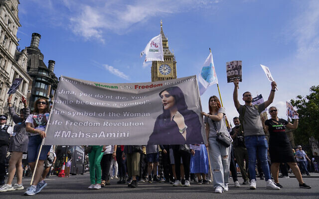 Demonstrators march in Parliament Square as they hold a banner, in London, September 16, 2023, as today marks the anniversary of the death of Mahsa Amini in Iran. (AP Photo/Alberto Pezzali)