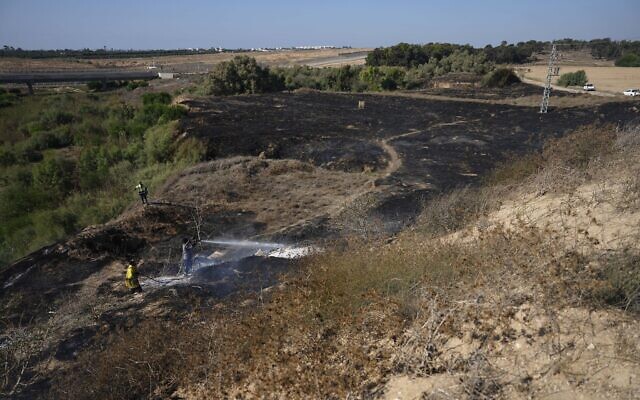Firefighters work to extinguish fires set by incendiary balloons launched from the Gaza Strip, setting vegetation ablaze near the Israel-Gaza border, September 22, 2023.(AP Photo/Tsafrir Abayov)