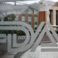 A US Food and Drug Administration building is seen behind FDA logos at a bus stop on the agency's campus in Silver Spring, Maryland, on August 2, 2018. (Jacquelyn Martin/AP)