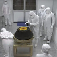 In this image from video provided by NASA, technicians in a clean room examine the sample return capsule from NASA's Osiris-Rex mission after it landed at the Department of Defense's Utah Test and Training Range on Sunday, Sept. 24, 2023. The sample was collected from the asteroid Bennu in October 2020. (NASA via AP)