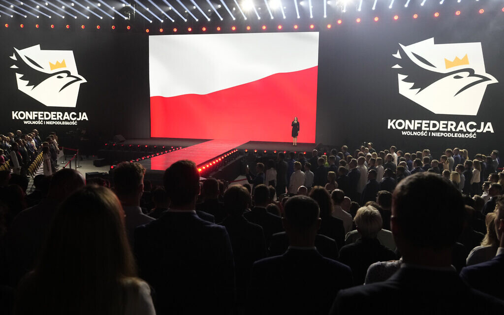 A woman sings the Polish national anthem at the start of a convention of the hard right Confederation party in Katowice, Poland, on September 23, 2023. (AP Photo/Czarek Sokolowski)