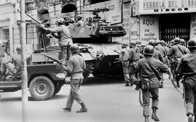 A reinforced platoon of soldiers ready for battle moves out, in search of 'suicide squad' in Santiago, Chile, allegedly formed by government sympathizers, September 13, 1973, after the coup two days prior against president Salvador Allende.  (AP Photo)