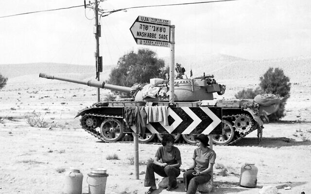 Two Israeli soldiers sit beneath a road sign, with a tank in the background, somewhere in the Sinai Desert, October 8, 1973. (AP Photo/Robert Dear)