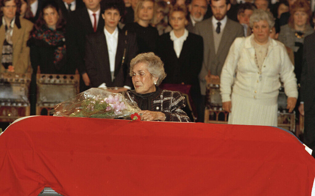 Hortensia Bussi de Allende, widow of Salvador Allende, places some flowers on her husband's coffin, covered with the Chilean flag, September 4, 1990. (AP Photo/Santiago Llanquin)
