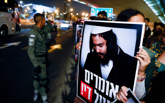 Far-right activists call for the release of Amiram Ben Uliel (pictured in poster), who was convicted of three counts of murder for the 2015 arson attack that killed three members of the Palestinian Dawabsha family, at the entrance to Jerusalem, September 1, 2022. (Olivier Fitoussi/Flash90)