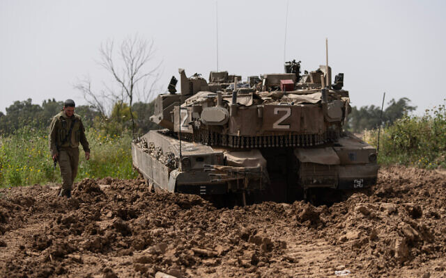 Israeli soldiers seen near an IDF tank stationed near the Gaza border on April 7, 2023. (Flash90/File)