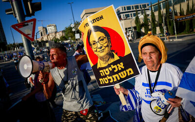 Right-wing Israelis, one carrying a sign showing Supreme Court President Esther Hayut and the slogan “The elite takes over,” attend a rally in support of the government's judicial overhaul, outside the Supreme Court in Jerusalem, on September 7, 2023. (Chaim Goldberg/Flash90)