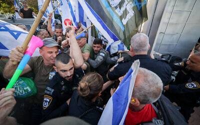 Protesters against the judicial overhaul scuffle with police outside the home of Justice Minister Yariv Levin in Modiin on September 11, 2023 (Yonatan Sindel/FLASH90)