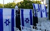 Activists from the Rosh Yehudi organization set up a "mechitzah" divider made of Israeli flags ahead of a public prayer event in Dizengoff Square, Tel Aviv, on Yom Kippur eve. September 24, 2023. (Tomer Neuberg/Flash 90)