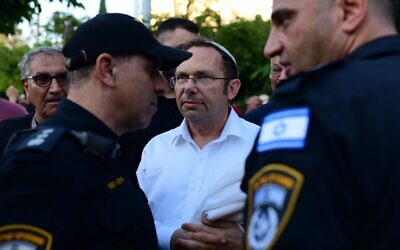 Israel Zeira, head of Rosh Yehudi, an Orthodox group, speaks with police officers amid protests after the group set up a gender divider for a Yom Kippur public prayer event at Dizengoff Square, in Tel Aviv, September 24, 2023. (Tomer Neuberg/Flash90)