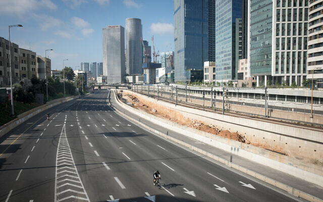 People ride their bicycles along the empty Ayalon highway in Tel Aviv, on  Yom Kippur, the Day of Atonement, September 25, 2023. (Miriam Alster/Flash 90)