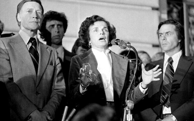 Then Acting Mayor Dianne Feinstein, with police Chief Charles Gain, at left, addresses the more than 25,000 people jammed around San Francisco's City Hall, Nov. 28, 1978, as residents staged a spontaneous memorial service for slain officials Mayor George Moscone and Supervisor Harvey Milk. (AP Photo/File)