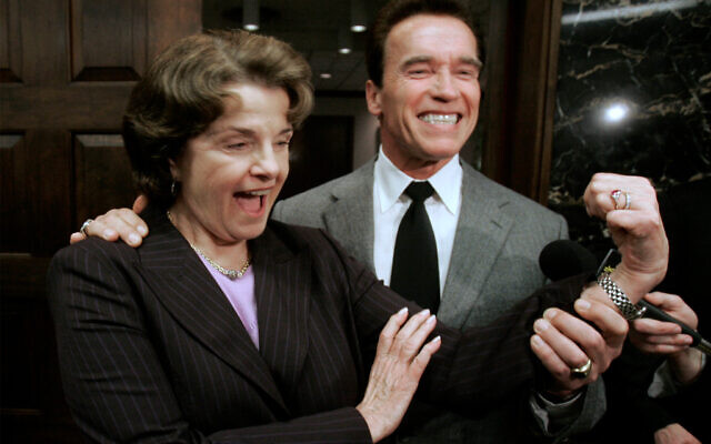 With the help of Gov. Arnold Schwarzenegger, US Sen. Dianne Feinstein flexes her bicep to show the muscle she will use to help Schwarzenegger come up with a water plan during a news conference at the Capitol, in Sacramento, California, February 21, 2008. (AP Photo/Rich Pedroncelli, File)
