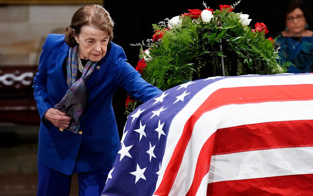 US Sen. Dianne Feinstein touches the flag-draped casket of former Sen. Bob Dole as he lies in state in the Rotunda of the US Capitol in Washington, December 9, 2021. (Ken Cedeno/Pool Photo via AP, File)