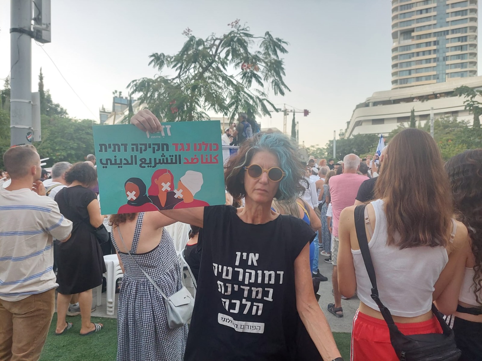 Shoham Smith protests against sex segregated prayer in Tel Aviv, Israel on September 25, 2023. Her t-shirt reads: "There is no democracy in a halachic state." Her signs reads: "We are all against religious legislation" in Hebrew and Arabic. (Cortesy)