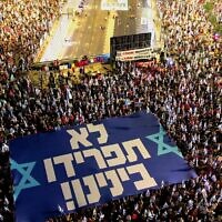 Protesters on Kaplan Street in Tel Aviv hold a sign declaring 'You won't divide us!,' September 30, 2023. (Amir Goldstein)