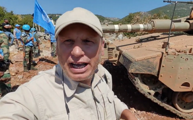 Ali Shoeib, a reporter for the Hezbollah-affiliated Al-Manar news outlet, stands next to an Israeli tank in the Mount Dov area along the border between Lebanon and Israel, while peacekeeping UNIFIL forces stand behind him, September 26, 2023. (Screenshot: X; used in accordance with Clause 27a of the Copyright Law)