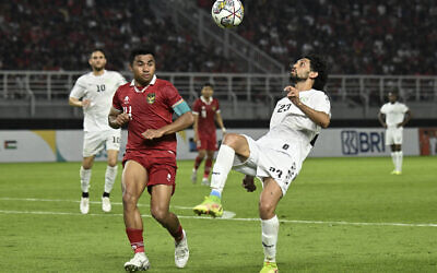 Palestine's Ataa Jaber (R) and Indonesia's Asnawi Mangkualam Bahar fight for the ball during the international friendly football match between Indonesia and Palestine at Gelora Bung Tomo stadium in Surabaya on June 14, 2023. (Photo by Juni Kriswanto / AFP)