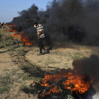 Palestinian protesters burn tires during clashes with Israeli security forces along the frontier with Israel, east of Gaza City, September 22, 2023. (AP Photo/Adel Hana)