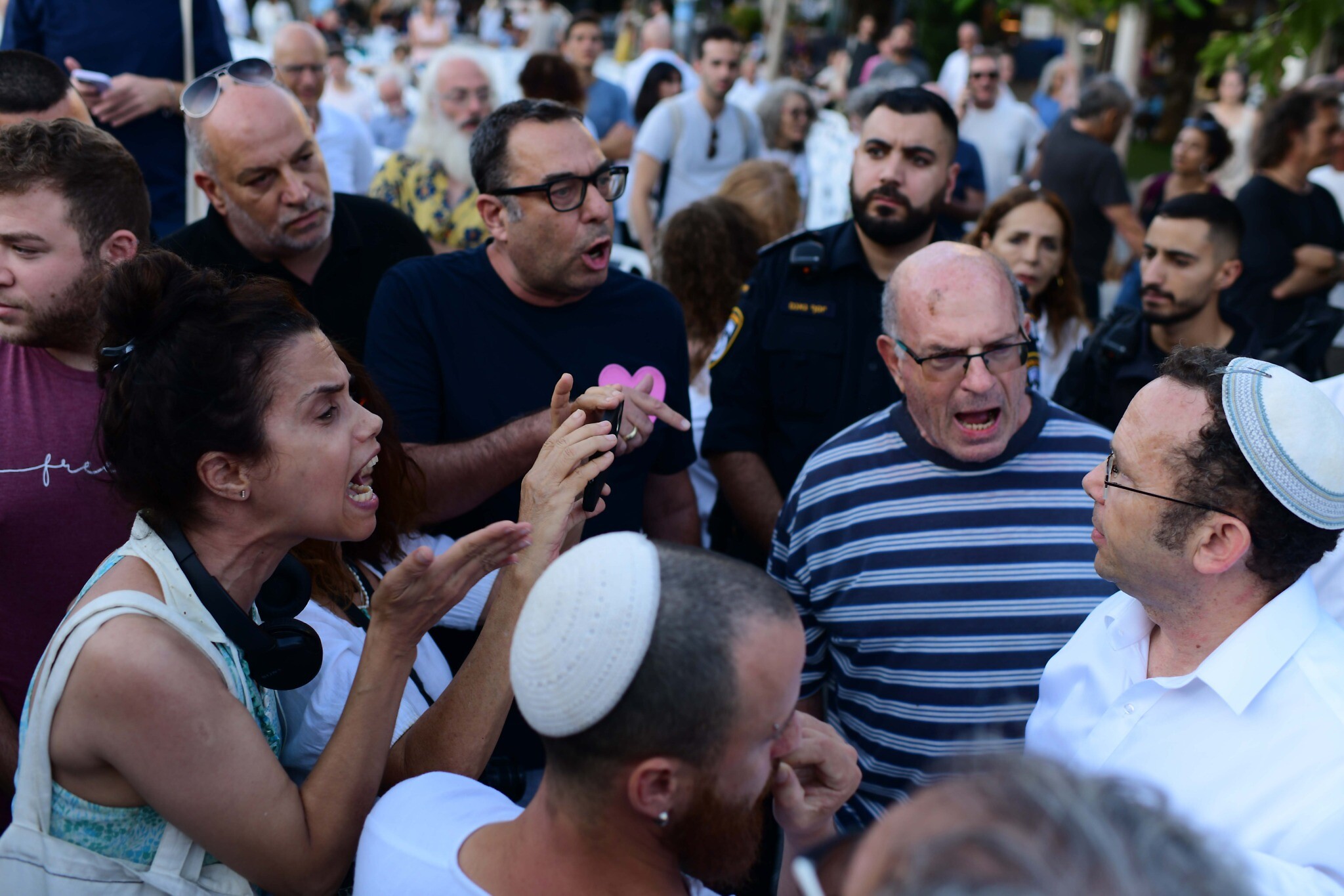 Protesters shout at Israel Zeira (right), founder of the Orthodox Jewish group Rosh Yehudi, which set up a gender divider for a public prayer event on Yom Kippur in Dizengoff Square in Tel Aviv, on September 24, 2023. (Tomer Neuberg/Flash 90)