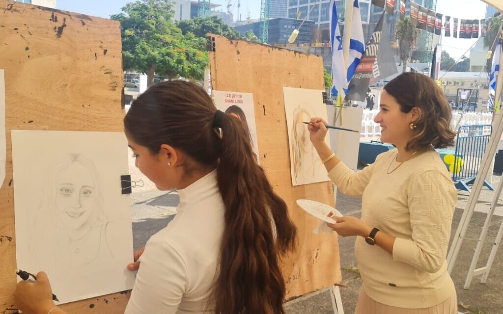 Hadar Gerzon painting a portrait of Shani Louk (right) and Tali Gerzon painting a portrait of Romi Gonen, as part of the This is Us project at the Tel Aviv Museum of Art, October 26, 2023. (Courtesy Yotzrim Seviva)