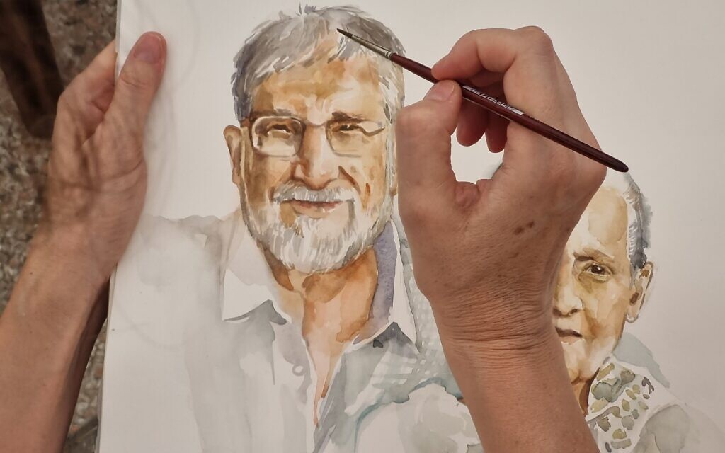 An artist paints a portrait of an Israeli hostage held by Hamas terrorists as part of the This is Us project at the Tel Aviv Museum of Art, October 26, 2023. (Bernard Dichek)