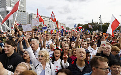 Demonstrators react as Polish opposition leader, former premier and head of the centrist Civic Coalition bloc, Donald Tusk (not pictured) addresses participants of a rally in Warsaw on October 1, 2023. (Wojtek Radwanski/AFP)
