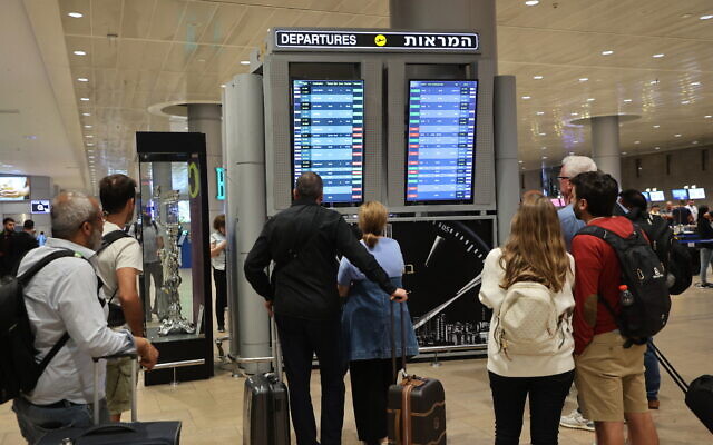 Passengers look at a departure board at Ben Gurion Airport near Tel Aviv, as flights are canceled and delayed because of a massive surprise attack by Hamas, on October 7, 2023. (Gil Cohen-Magen/AFP)