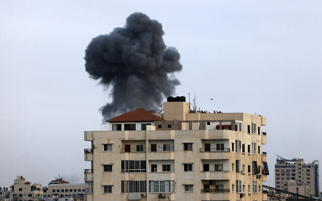 A plume of smoke rises above buildings in Gaza City during an Israeli air strike, on October 8, 2023. (MAHMUD HAMS / AFP)