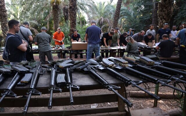 Israelis arrive at a weapons distribution point for people allowed to carry arms, at the Ayyelet HaShahar Kibbutz, in northern Israel, near the Lebanese border on October 12, 2023. (Jalaa MAREY / AFP)