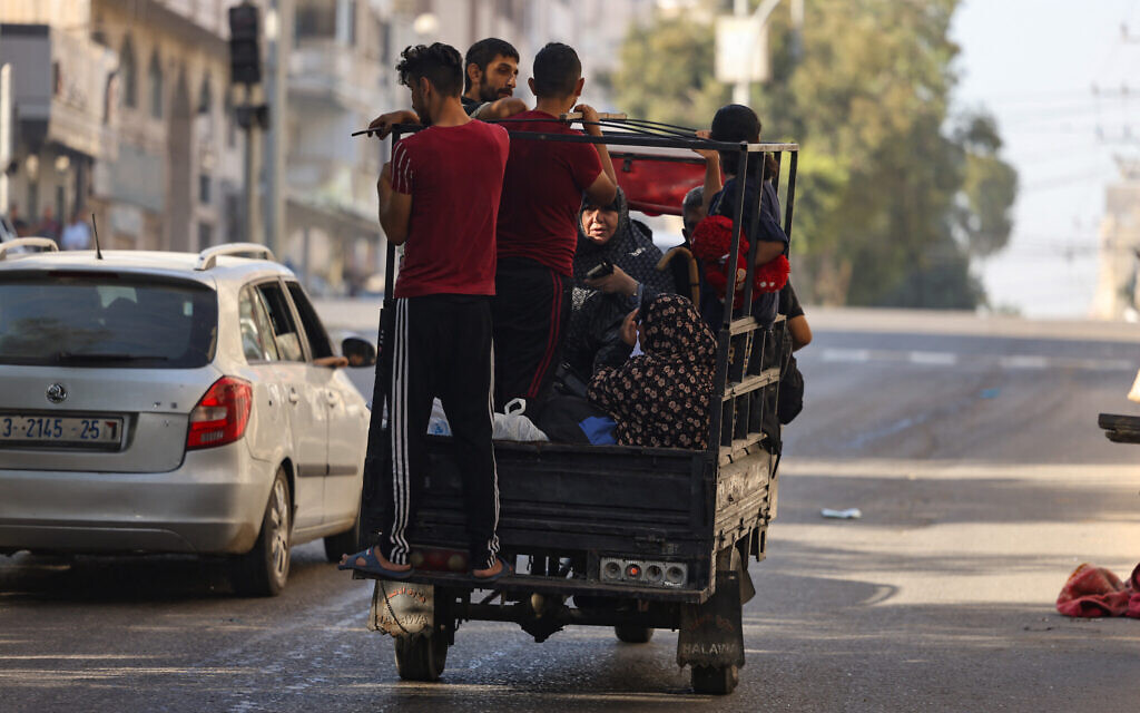 Palestinians carrying their belongings flee to safer areas in Gaza City after Israeli air strikes, on October 13, 2023. (MOHAMMED ABED / AFP)