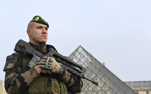 A soldier stands guard at the entrance of the Louvre's Pyramid in Paris on December 30, 2016.  (Photo by ALAIN JOCARD / AFP -- File)
