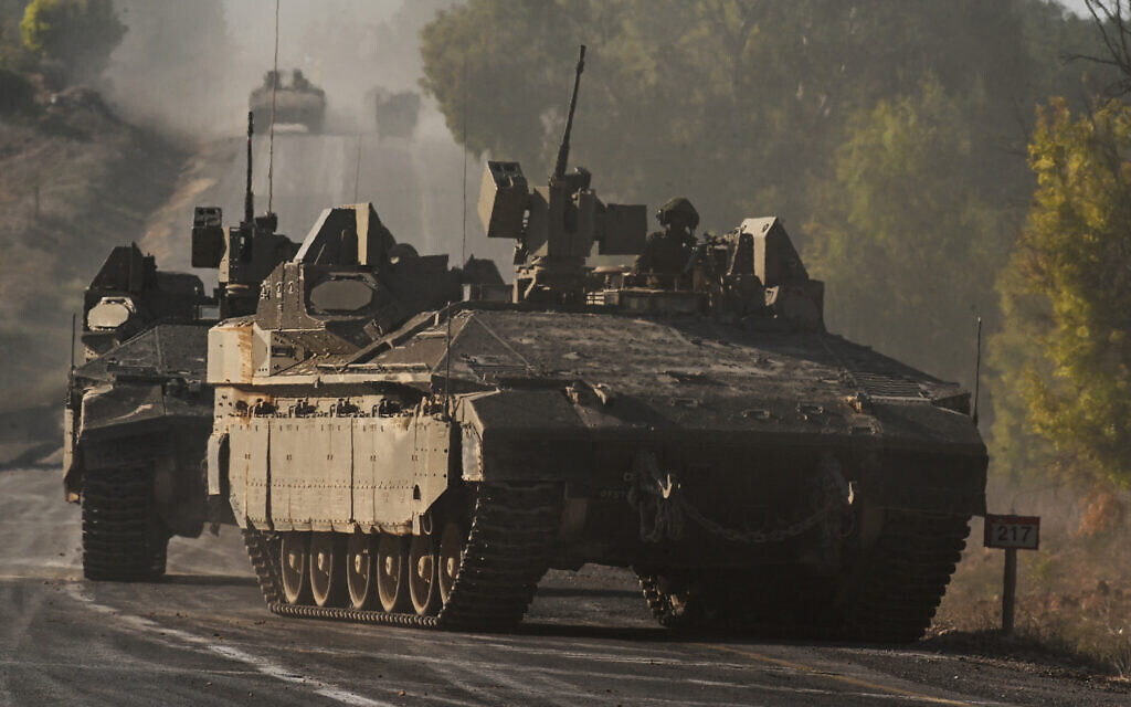 Israeli army armoured vehicles roll towards the border with the Gaza Strip at an undisclosed location in southern Israel on October 15, 2023. (Photo by YURI CORTEZ / AFP)