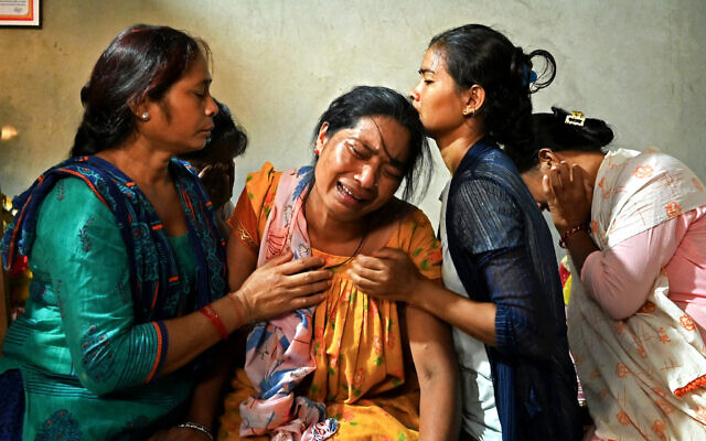Manju Devi Danguara (2nd left), the mother of Ashish Chaudhary, is consoled by family members at her residence in the Kailali district of Sudurpashchim province as she mourns the loss of her son, who was killed in Hamas's devastating onslaught in Israel, October 13, 2023. (Prakash MATHEMA/AFP)